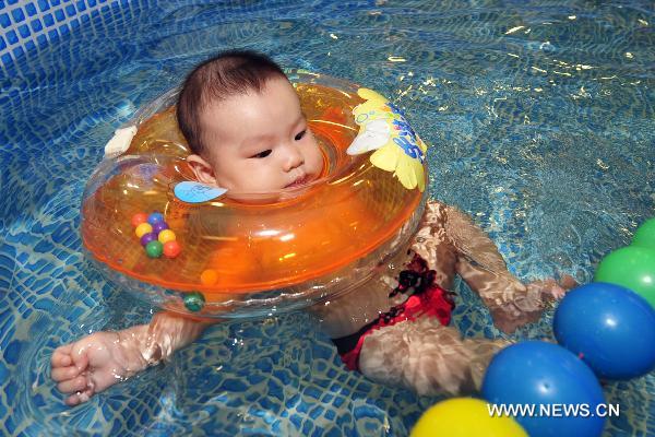 A five-month-old baby swims in the final of a swimming competition for babies of 0-3 years of age in Hangzhou, capital of east China&apos;s Zhejiang Province, Aug. 22, 2010. [Xinhua]