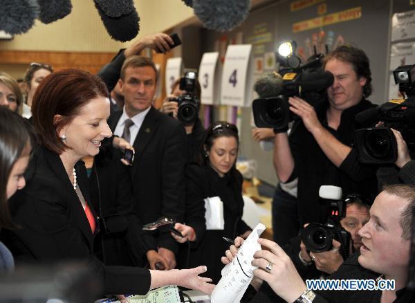 Australian Prime Minister Julia Gillard (L) is going to cast her vote at Melbourne's Seabrook Primary School polling station, Aug. 21, 2010. [Bai Xue/Xinhua]
