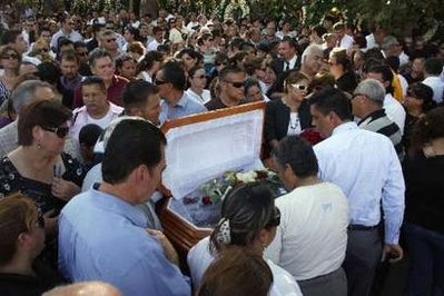 Relatives and friends gather around the coffin of Edelmiro Cavazos, mayor of the tourist town of Santiago, prior to his funeral at a cemetery downtown in the municipality of Santiago, some 30 km (18.6 miles) from Monterrey, August 19, 2010. [Agencies]