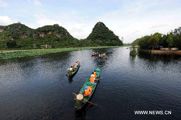 Tourists enjoy their time in boats in Zhuang-Miao Autonomous Prefecture of Wenshan, southwest China's Yunnan Province, Aug. 21, 2010. [Xinhua/Yang Zongyou]