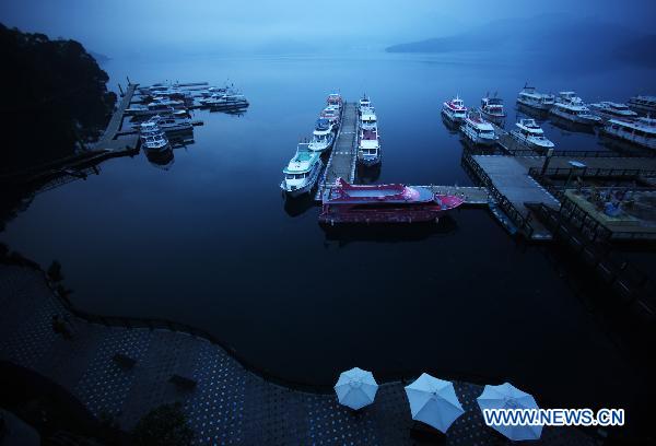 Boats are moored to the berth in Riyue Tan, or the Sun Moon Lake, southeast China's Taiwan, at dawn on Aug. 22, 2010. [Xinhua/Fei Maohua]