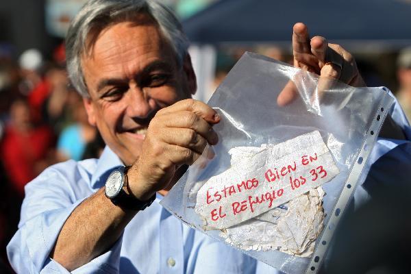 Chilean President Sebastian Pinera shows a note reading 'we are fine in the shelter, the 33 of us' from the 33 miners trapped in a copper mine near Copiapo in north Chile, Aug. 22, 2010. Pinera said on Sunday that the 33 miners trapped since Aug. 5 in a copper mine are still alive.[Xinhua]
