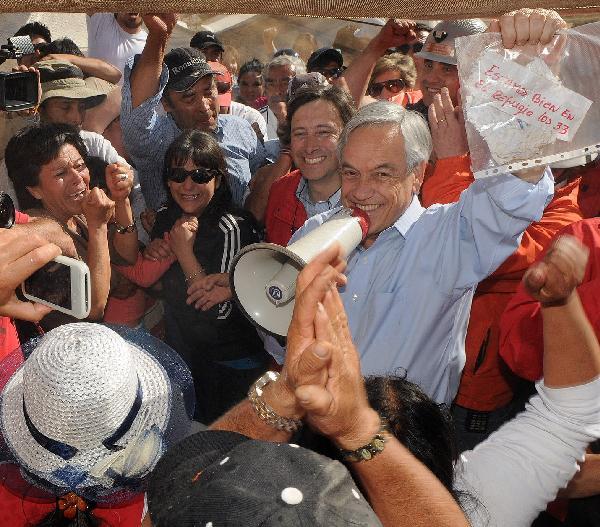 Chilean President Sebastian Pinera shows a note reading 'we are fine in the shelter, the 33 of us' from the 33 miners trapped in a copper mine near Copiapo in north Chile, Aug. 22, 2010. Pinera said on Sunday that the 33 miners trapped since Aug. 5 in a copper mine are still alive. [Chilean Presidential Service/Xinhua]