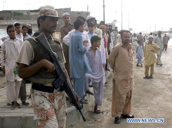 A security officer guards on a road after a protest against a target killing in southern Pakistan&apos;s Karachi, Aug. 22, 2010. (Xinhua/Arshad)