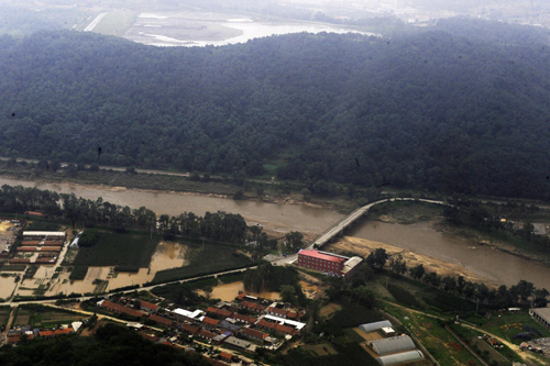 An aerial photo shows houses are inundated in flood waters in Dandong, northeast China's Liaoning province on August 22, 2010. About 99,000 people have been evacuated and at least four killed as heavy rains triggered landslides and breached banks of the Yalu River, inundating houses and farmland in China and DPRK.[Photo/Xinhua]
