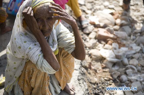 An old flood refugee squats on ground near Muzaffargarh, south Pakistan&apos;s Punjab Province, Aug. 23, 2010. [Xinhua]