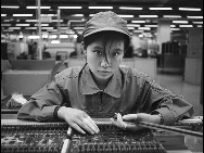 Female worker Wang Fan works on an assembly line in 2003. [QQ.com]