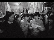 Female workers of a foreign toy factory in Huatian of Bao'an District read a letter from home in   their dormitory in 1992. [QQ.com]