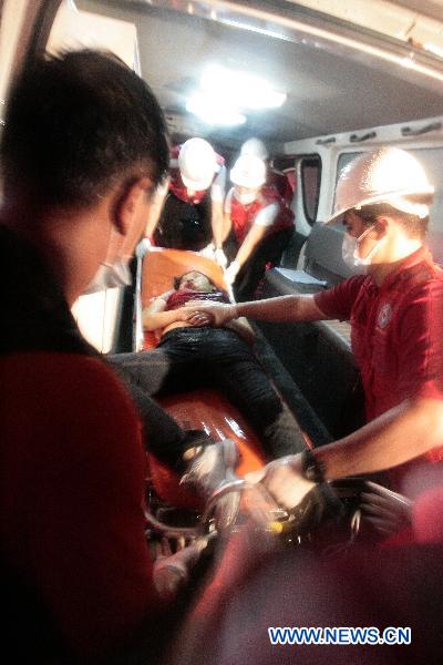 An injured victim is carried into an ambulance after a hostage-taker opened fired from inside a tourist bus full of Hong Kong tourists during a hostage crisis in Manila Aug. 23, 2010. [Rouelle Umali/Xinhua]