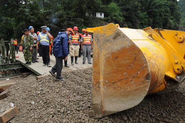 A bulldozer clears the road around a new bridge in Gongshan county, Southwest China&apos;s Yunnan province, Aug 24, 2010. [Xinhua]