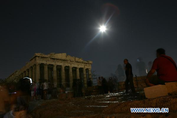 The full moon illuminates the sky over the Acropolis hill in Athens, capital of Greece, on August 24, 2010. Continuing a tradition which started 13 years ago, the Greek Ministry of Culture and Tourism kept 92 archaeological sites across Greece open free to the public on the night of August full moon Tuesday. [Xinhua/Marios Lolos] 