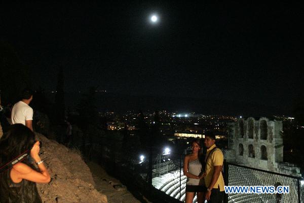 The full moon illuminates the sky over the Acropolis hill in Athens, capital of Greece, on August 24, 2010. [Xinhua/Marios Lolos]