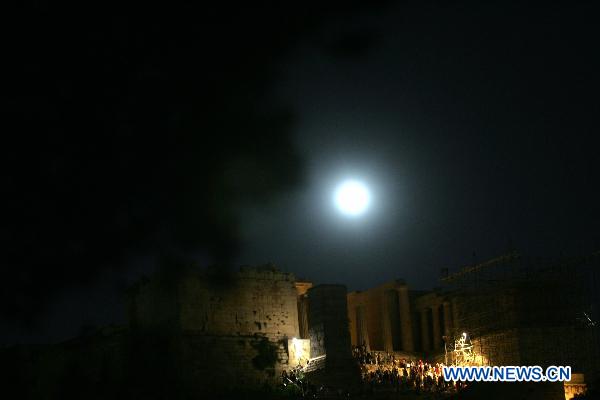 The full moon illuminates the sky over the Acropolis hill in Athens, capital of Greece, on August 24, 2010. [Xinhua/Marios Lolos]