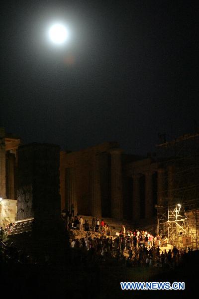 The full moon illuminates the sky over the Acropolis hill in Athens, capital of Greece, on August 24, 2010. [Xinhua/Marios Lolos]