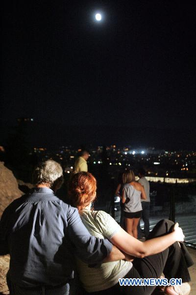 The full moon illuminates the sky over the Acropolis hill in Athens, capital of Greece, on August 24, 2010. [Xinhua/Marios Lolos]