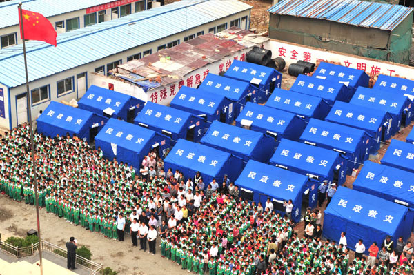 A flag-raising ceremony is held at the No 1 Primary School in Zhouqu county, Northwest China&apos;s Gansu province, Aug 25, 2010. More than 7,000 primary and middle school students in the mudslide-battered county began their new semester Wednesday, after the disaster claimed 1,447 lives on Aug 8. [Xinhua]