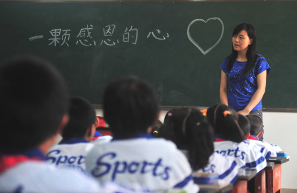  A teacher gives a lesson about gratitude in her first class of the new semester at the No 2 Primary School in Zhouqu county, Northwest China&apos;s Gansu province, Aug 25, 2010. The words on the blackboard read: &apos;A grateful heart.&apos; [Xinhua]
