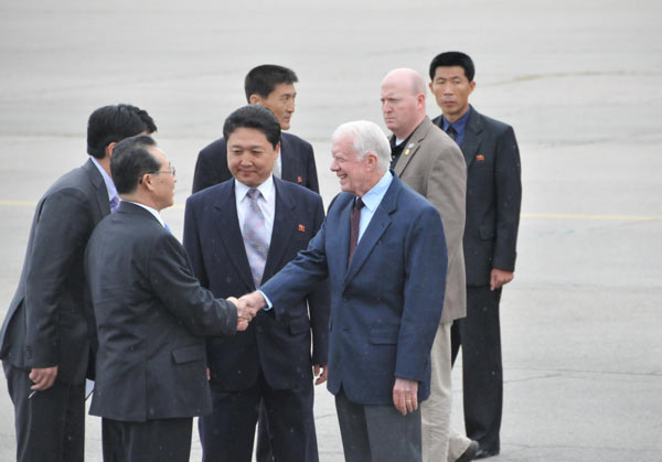 Former US President Jimmy Carter (R) shakes hands with DPRK&apos;s vice foreign minister Kim Kye Gwan at the airport in Pyongyang, Aug 25, 2010. [Xinhua]