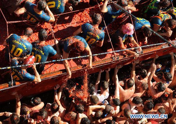 Revellers throw tomatoes to each other during the annual &apos;Tomatina&apos; (tomato fight) in the Mediterranean village of Bunol, near Valencia, Spain, on Aug. 25, 2010. [Xinhua]