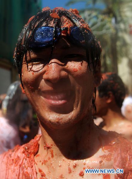 A reveller is pelted with tomatoes during the annual &apos;Tomatina&apos; (tomato fight) in the Mediterranean village of Bunol, near Valencia, Spain, on Aug. 25, 2010. [Xinhua]