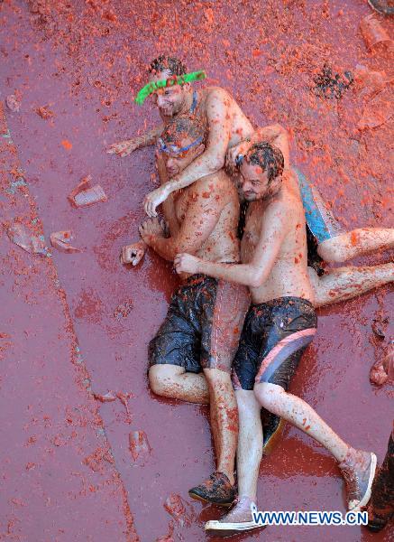 Revellers throw themselves into tomato pulp during the annual &apos;Tomatina&apos; (tomato fight) in the Mediterranean village of Bunol, near Valencia, Spain, on Aug. 25, 2010. [Xinhua] 