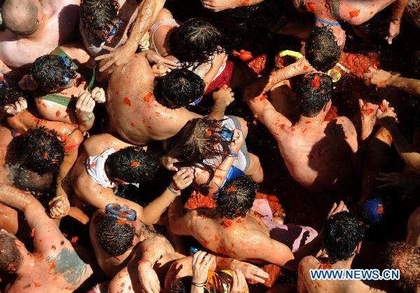 Revellers throw tomatoes to each other during the annual &apos;Tomatina&apos; (tomato fight) in the Mediterranean village of Bunol, near Valencia, Spain, on Aug. 25, 2010.[Xinhua]