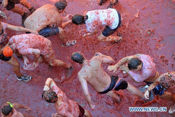 Revellers throw tomatoes to each other during the annual &apos;Tomatina&apos; (tomato fight) in the Mediterranean village of Bunol, near Valencia, Spain, on Aug. 25, 2010.[Xinhua]