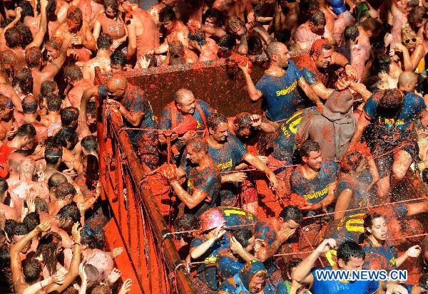 Revellers throw tomatoes to each other during the annual &apos;Tomatina&apos; (tomato fight) in the Mediterranean village of Bunol, near Valencia, Spain, on Aug. 25, 2010. [Xinhua]