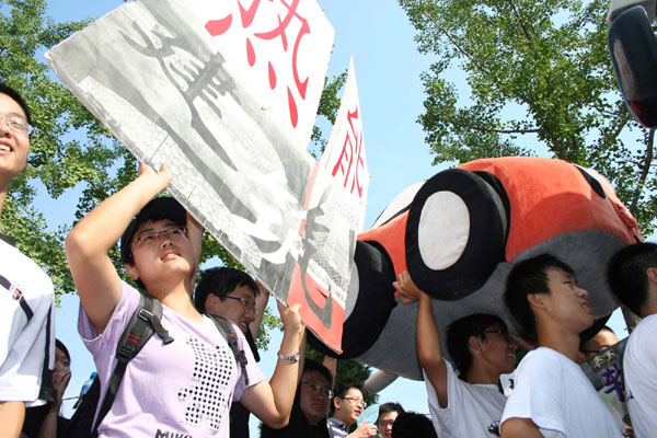 Seniors at Tsinghua University in Beijing wave posters and mascots to welcome freshmen on Aug 25. The university admitted more than 3,000 freshmen this year. Some seniors helped new students get familiar with the university. [Xinhua]