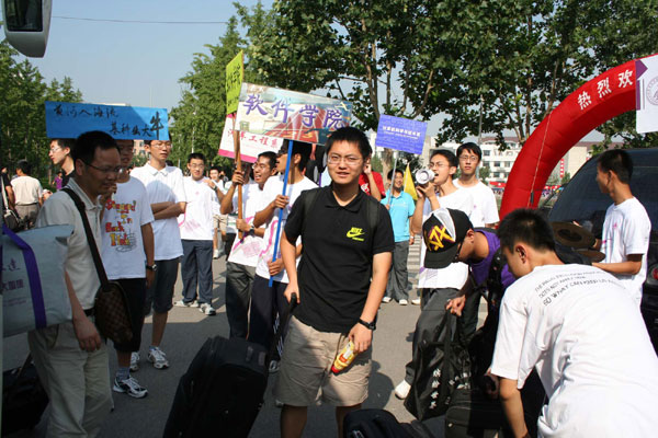 A freshman walks through the welcome gate on Aug 25. Tsinghua University admitted more than 3,000 freshmen this year. Some seniors helped new students get familiar with the university. [Xinhua]