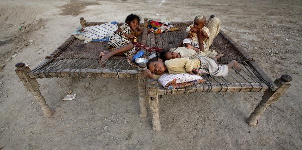 Children who are flood victims rest on handmade rope beds while taking refuge from the flood with their family at the Al Mujahid Army Relief Camp in Sukkur, in Pakistan&apos;s Sindh province, August 25, 2010.[Xinhua]