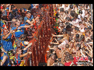 Revellers throw tomatoes to each other during the annual 'Tomatina' (tomato fight) in the Mediterranean village of Bunol, near Valencia, Spain, on Aug. 25, 2010. [Chinanews.com]