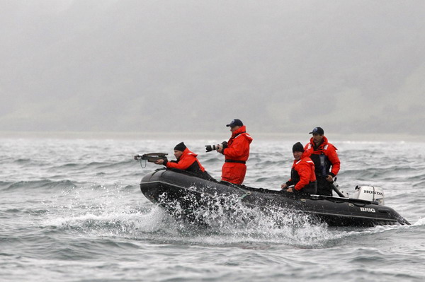 Russia&apos;s Prime Minister Vladimir Putin (L) fires darts with a crossbow at an endangered grey whale from a motorboat in Olga Bay in the Sea of Japan, August 25, 2010. [China Daily/Agencies]