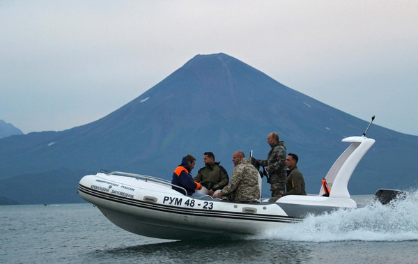 Russia&apos;s Prime Minister Vladimir Putin (2nd R) operates a motorboat as he visits Yuzhno-Kamchatsky wildlife preserve near the Far East city Petropavlovsk-Kamchatsky, August 24, 2010. [China Daily/Agencies]