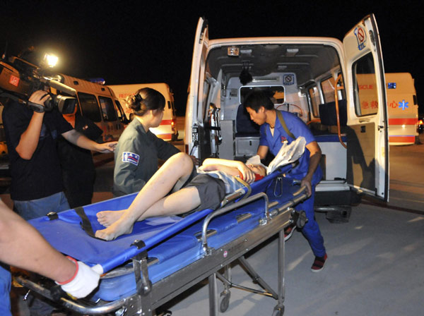 Rescue workers try to load an injured man onto an ambulance at the Harbin Taiping International Airport, Aug 25, 2010. [Xinhua]