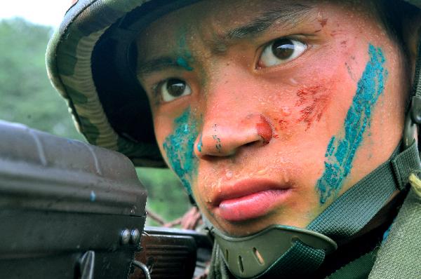 A sharp-shooter of armed police aims with the gun during an anti-terrorism drill in Chuzhou, east China&apos;s Anhui Province, Aug. 23, 2010. The anti-terrorism maneuver involved some 50 task force members. [Xinhua]