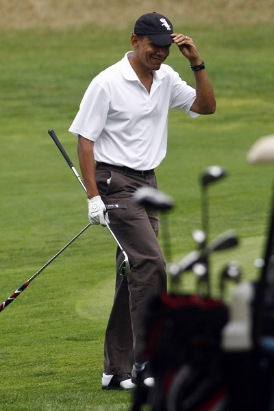 U.S. President Barack Obama tips his cap to the crowd after chipping onto the green on the ninth hole while playing golf at Mink Meadows Golf Club in Vineyard Haven on Martha&apos;s Vineyard, Massachusetts August 25, 2010. The first family is on a 10-day summer vacation.[Xinhua/Reuters]