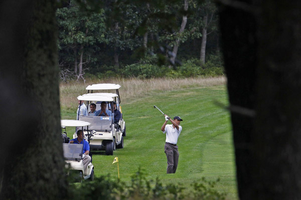  U.S. President Barack Obama hits a shot from the fairway on the ninth hole while playing golf at Mink Meadows Golf Club in Martha&apos;s Vineyard in Vineyard Haven, Massachusetts, August 25, 2010. The first family is on a 10-day summer vacation.[Xinhua/Reuters]