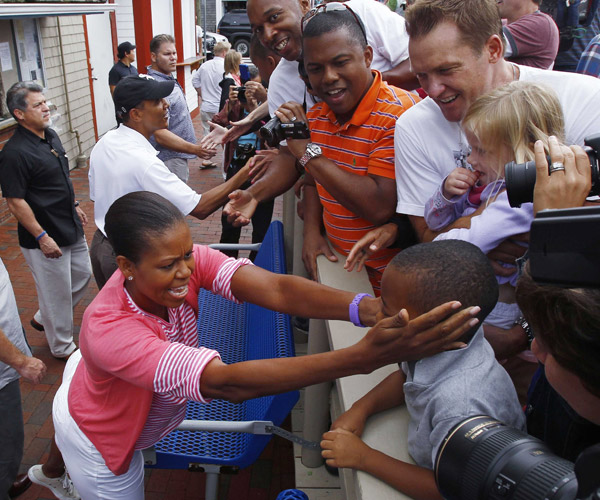 U.S. President Barack Obama and first lady Michelle Obama greet people as they arrive for lunch at Nancy&apos;s Restaurant in Martha&apos;s Vineyard in Oak Bluffs, Massachusetts, August 25, 2010. The first family is on a 10-day summer vacation.[Xinhua/Reuters]