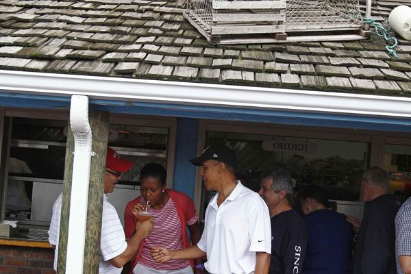 U.S. first lady Michelle Obama takes a sip of a drink from friend Dr. Eric Whitaker as President Barack Obama looks on as they arrive for lunch at Nancy&apos;s Restaurant in Martha&apos;s Vineyard in Oak Bluffs, Massachusetts, August 25, 2010. The first family is on a 10-day summer vacation.[Xinhua/Reuters] 