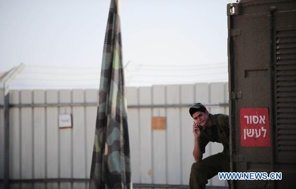 An armed Israeli makes a private call in an Israeli military base near the Israel-Lebanon border, on Aug 25, 2010.[Yin Dongxu/Xinhua]