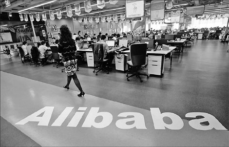 Employees working at an Alibaba office in Hangzhou. The company's recent acquisitions may boost customer numbers by 250,000. [China Daily]