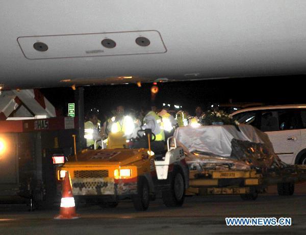 Coffins of victims were unloaded from a plane in Hong Kong, south China, Aug. 25, 2010. The charter plane carrying tourist group members, victims' relatives and the bodies of the eight victims killed in Monday's hostage crisis in the Philippines arrived at Hong Kong Wednesday.