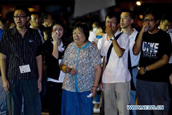 Relatives cry as they see the coffins of victims in Hong Kong, south China, Aug. 25, 2010. The charter plane carrying tourist group members, victims' relatives and the bodies of the eight victims killed in Monday's hostage crisis in the Philippines arrived at Hong Kong Wednesday.