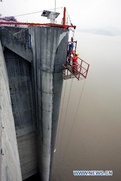 Worker brushes protective coating onto the Three Gorges Dam on Aug. 24, 2010. China Three Gorges Corporation began to coat protective painting materials onto the Three Gorges Dam to protect the concrete structure.