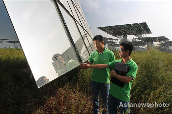 Technicians examine heliostats used in a solar thermal power tower system in Yanqing County, Beijing, Aug 25, 2010. 