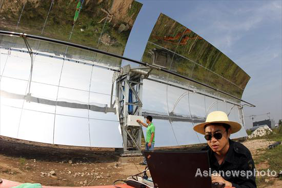 Technicians examine heliostats used in a solar thermal power tower system in Yanqing County, Beijing, Aug 25, 2010. 