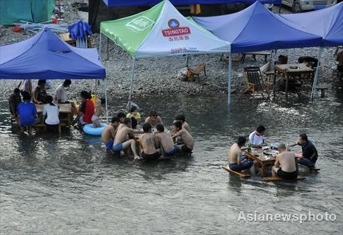 People have dinner in a village river in Kaili, Southwest China's Guizhou province on August 9, 2010. [Photo/Asianewsphoto] 