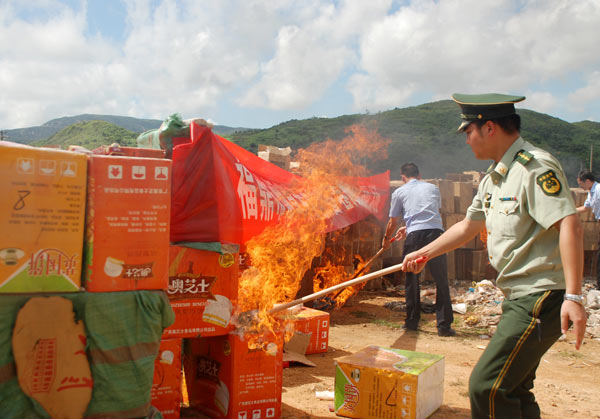 Policemen set fire to boxes of fake cigarettes in Fuding, Southeast China&apos;s Fujian province, Aug 26, 2010. [Xinhua]