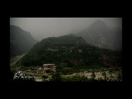 Huangtang Primary School, the white building in the picture, is the only school for the nearby villages for children in third grade and below. Only four students attended the school last semester. [China.org.cn]